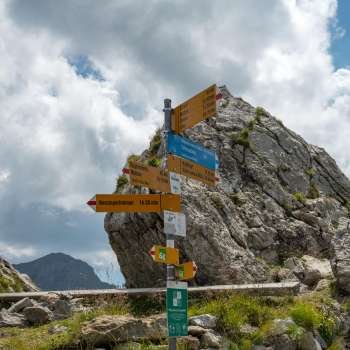 Signpost at the Pfälzerhütte hut distance information to hiking destinations in Liechtenstein.