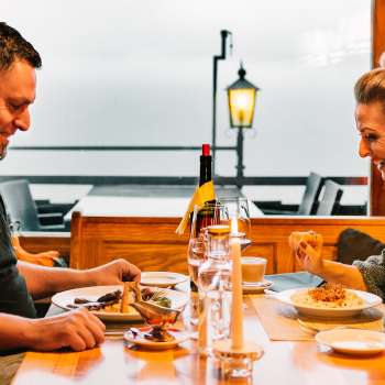 Couple enjoys a cozy candlelit dinner with a view of the outdoor area
