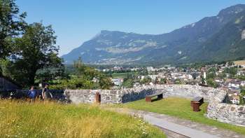 Walk through an avenue of trees with a view of Gutenberg Castle and the Alpine scenery in the background