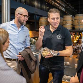 An employee explains brewing ingredients to a group of interested guests during a tour of the brewery.