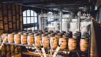 Brewing kettle and wooden barrels in the stylish interior of the Liechtensteiner Brauhaus brewery's brewhouse