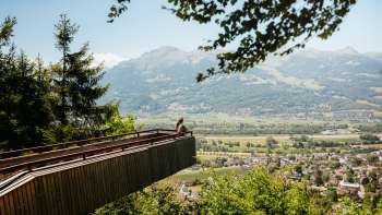 Viewing platform on the forest adventure trail in Vaduz with a view of the sunny valley